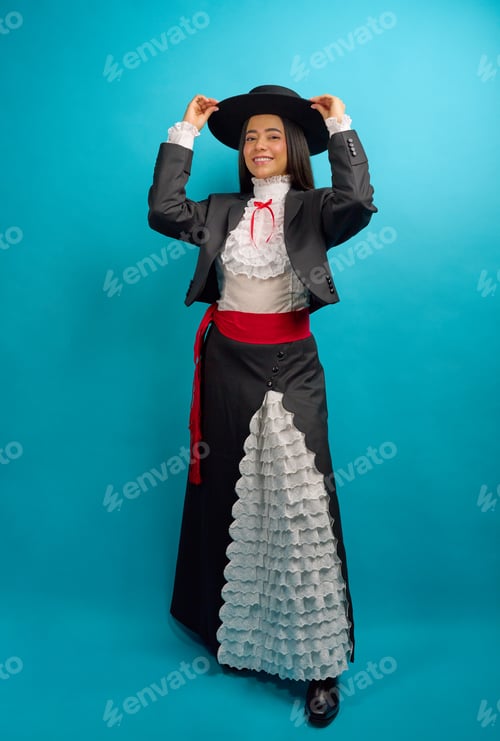 Preview: Studio portrait of a young latina woman proudly wearing a traditional chilean huasa dress