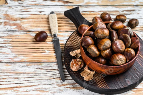 Preview: Bowl with chestnuts on a wooden table. White background. Top view. Copy space