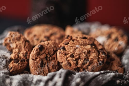 Preview: Chocolate chip cookies on red background and white napkin. Big close up view