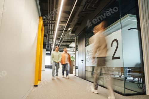 Preview: motion blur of modern business people working in corridor along meeting room in contemporary