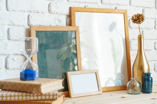 Preview: Wooden frame mockup on table with modern vase and books