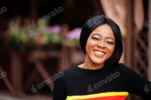 Preview: African American woman with bright make-up posing outdoor.