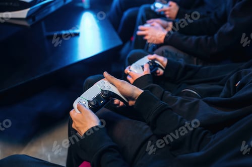 Preview: Holding controllers. Close up view of hands of gamers that playing game on console