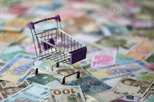 Preview: Supermarket trolley on many banknotes of different currency. Background of shopping worldwide