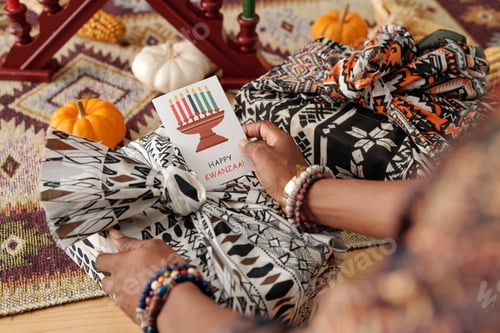 Preview: Hand of woman holding Kwanzaa postcard