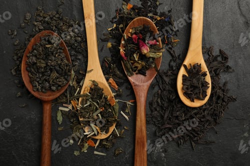 Preview: Different types of tea brew on black table, flat lay