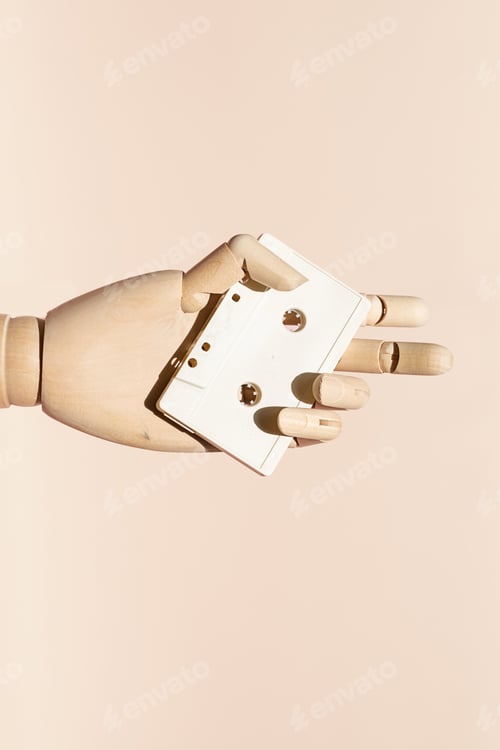 Preview: Wooden Hand Holding White Audio Cassette. Retro Technology and Music Concept.