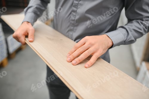 Preview: A young man chooses laminate flooring in the hardware store