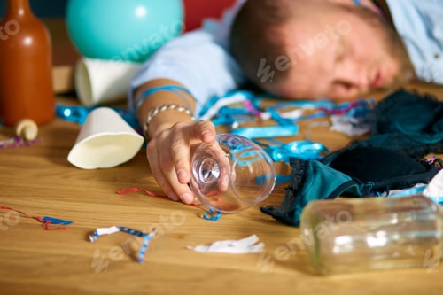 Preview: Bearded man sleeping at table in messy room after bachelor party