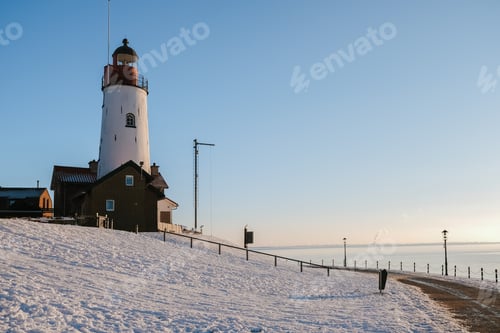 Preview: Lighthouse of Urk during winter with snow in the Netherlands on a sunny day