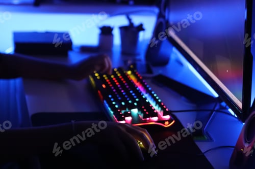 Preview: Gamer. A teenager is playing on the computer in the evening time.
