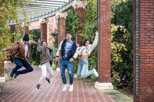 Preview: group of four students friends jumping on campus