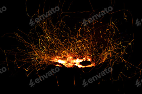 Preview: Campfire flame sparks long exposure isolated on black background. Fire sparkles long exposure