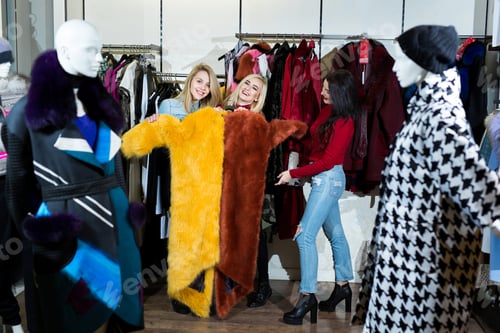 Preview: Three women trying on a fur coat in the store