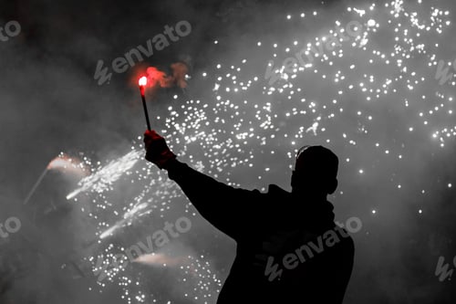 Preview: Silhouette shot of a man holding a red colored smoke stick