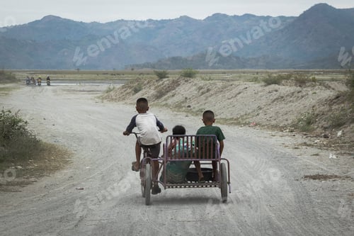 Preview: Three Filipino kids riding down a rural dirt road