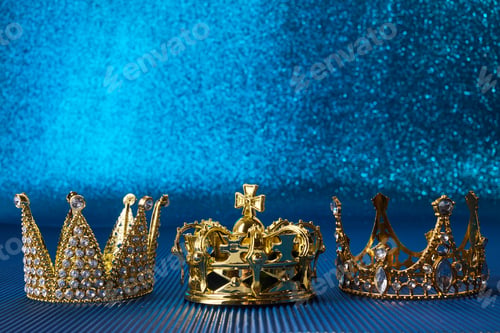 Preview: Epiphany Day or Dia de Reyes Magos concept. Three gold crowns on blue sparkling background