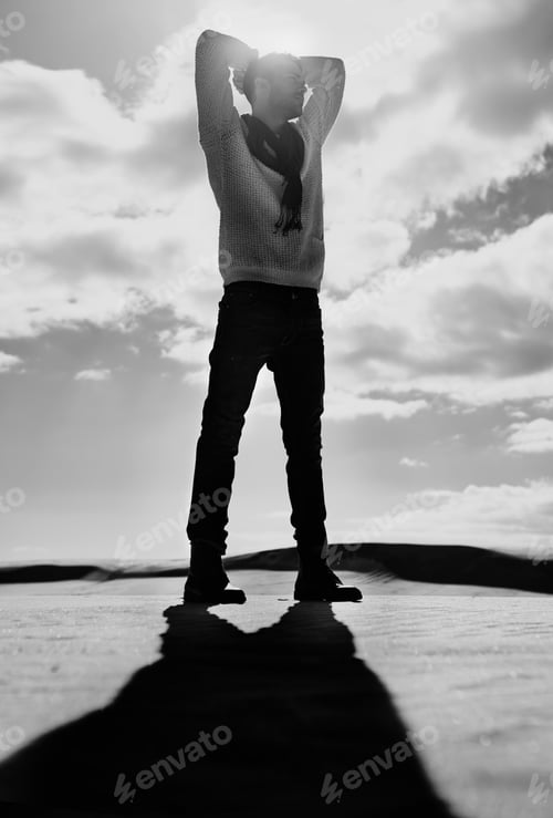 Preview: Man versus the elements. Full length monochrome shot of a man standing in a desert landscape.