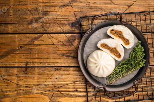 Preview: Chinese Bao Baozi steam bun with meat on steel tray. wooden background. top view