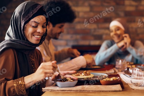 Preview: Young happy Muslim woman enjoying in Ramadan meal with her friends.