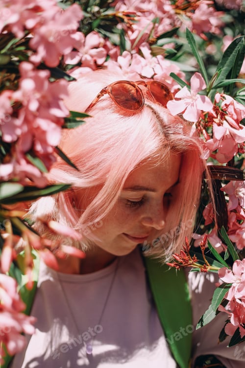 Preview: Beautiful young woman millennial, pink oleanders flowers