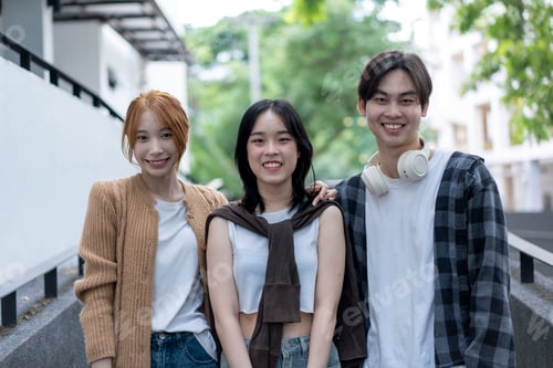 Preview: Three young people are smiling for the camera, with one wearing a brown jacket
