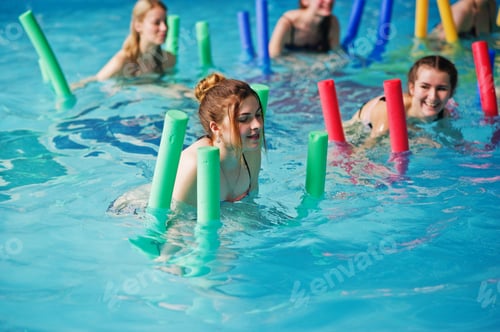 Preview: Fitness group of girls doing aerobical excercises in swimming pool