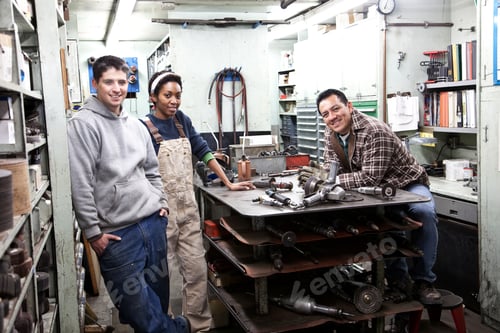 Preview: Mixed race team of workers and management people in a large sheet metal factory