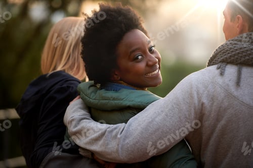 Preview: This is my college family. Rearview shot of three young students on campus.