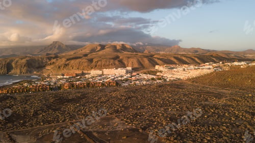 Preview: Aerial view of mountains and marine coast, village of houses, dry terrain and trails, Canary Islands