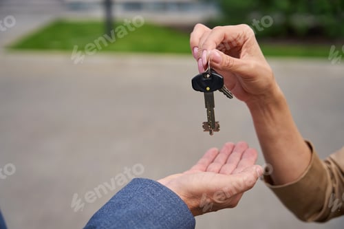 Preview: Woman hand puts in man palm keys to new cottage
