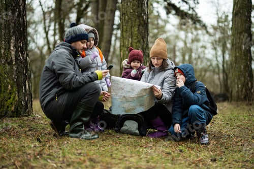 Preview: Family and kids with map in the forest.