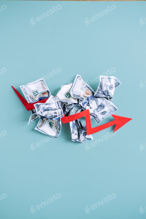 Preview: Red arrow points downward over pile of crumpled dollar bills on blue background. Economic recession