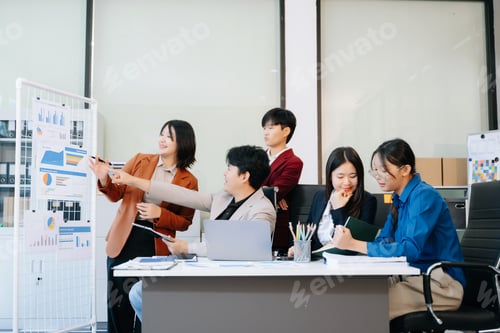 Preview: Group of diverse businesspeople using a laptop and tablet in office.