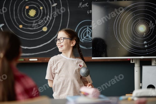 Preview: Caucasian Girl Smiling While Presenting Solar System Model in Classroom