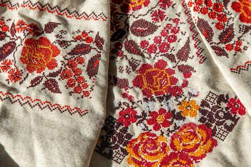Preview: Ukrainian clothes embroidered shirt. Red orange and black threads background. Vyshyvanka is a symbol
