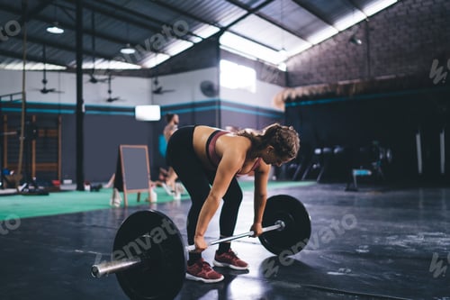 Preview: Fit Woman Lifting Barbell in Gym