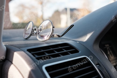 Preview: Glasses on the dashboard of a car. Accessory for drivers with vision problems. Road safety concept.