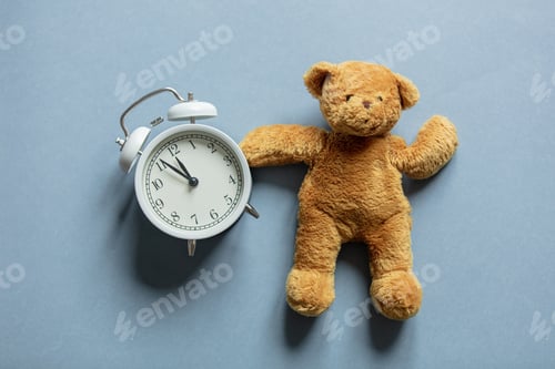 Preview: Vintage alarm clock and teddy bear toy on gray background