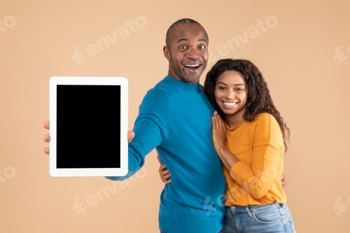 Preview: New app. Happy black couple showing digital tablet with mockup, promoting application or website