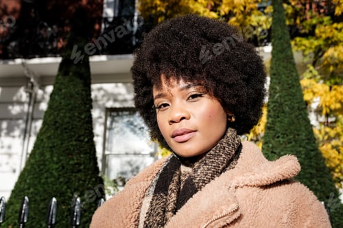 Preview: Head-shot of young black curly woman looking at camera with confident.