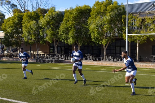 Preview: Three African American young male athletes training on sunny rugby field outdoors