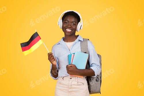 Preview: Happy teen african american woman student in wireless headphones, with books, flag of Germany