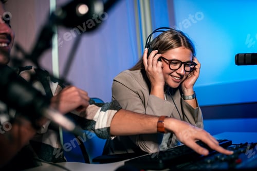 Preview: Young woman and man editing audio podcast in their studio.