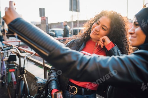 Preview: Young woman and friend taking selfie in city