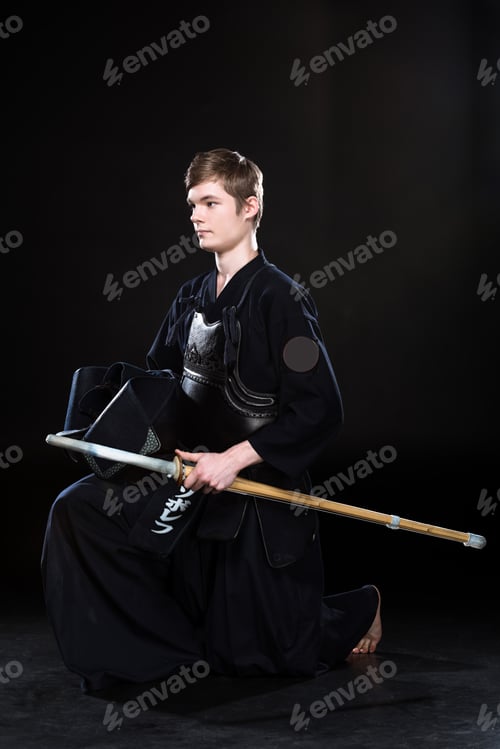 Preview: Young man practicing kendo with sowrd on black