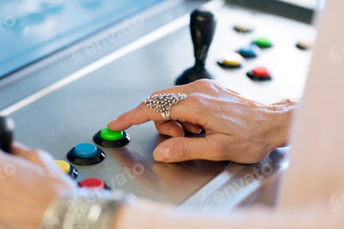 Preview: Close up of senior womans hand pressing button on games machine