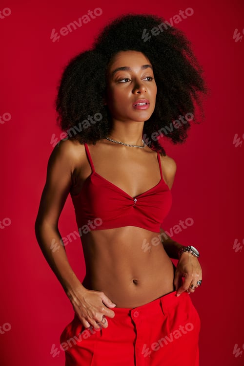 Preview: sexy alluring african american woman in red vibrant bra posing on red background and looking away