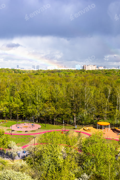 Preview: sunlit playground and park after rain with rainbow