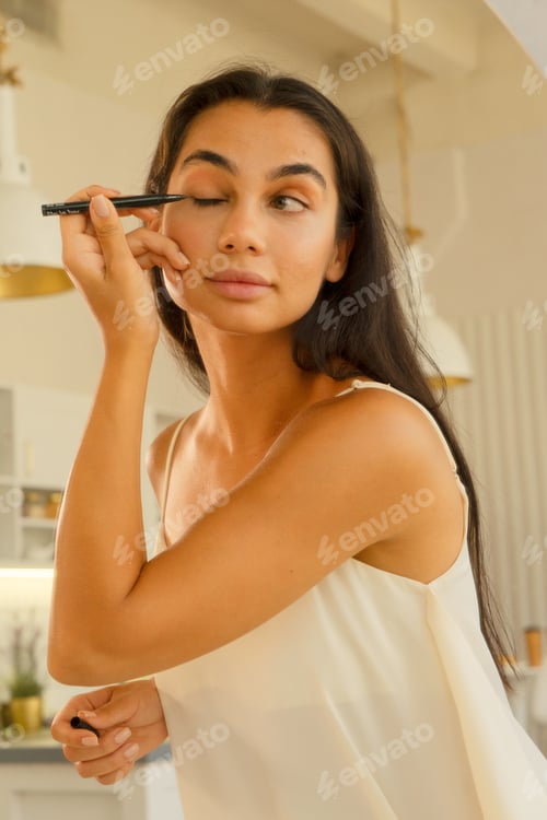 Preview: brunette woman with long straight dark hair and clean skin doing make up routine